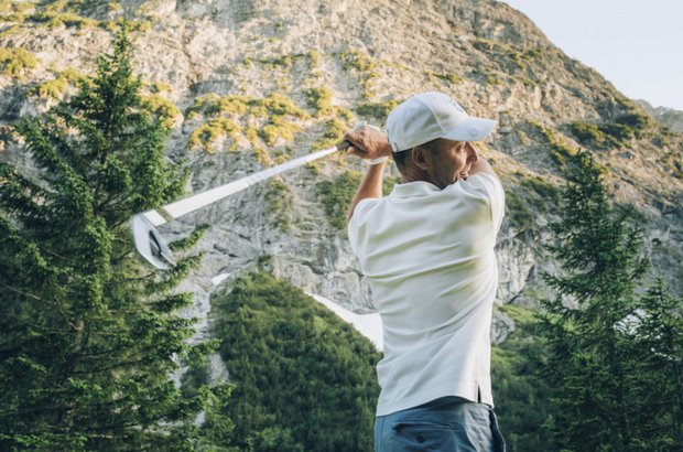 Golfen in Lech Golfer schwingt den Golfschläger zum Abschlag.