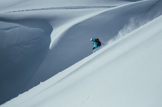 Skifahrer genießt die Abfahrt übe die weiße Landschaft.