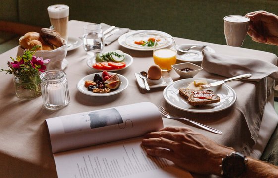 Aurora Frühstückstisch Frühstückstisch gedeckt mit frischem Obst, Brot, gekochtes Ei, Kaffee und frisch gepresstem Orangensaft.