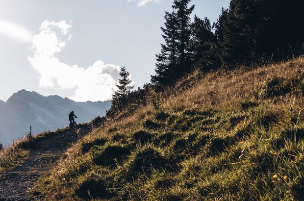Mountainbiketour in Lech Schotterstraße am Berg mit einem Radfahrer.